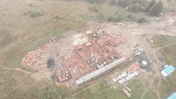 Workers and heavy machinery work on building site. Construction industry