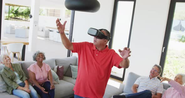 Happy senior diverse people using vr headset at retirement home