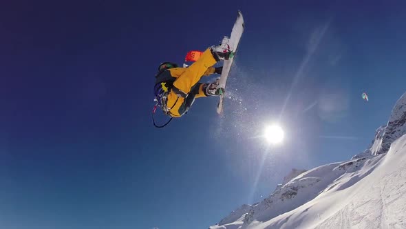 A young man snow kiting on a snowboard.