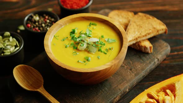 Fresh Pumpkin Soup in Bowl on Chopping Board