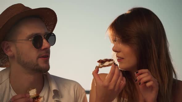 Closeup Attractive Man Wearing Glasses and Straw Hat Eating Snack and Talking to Girl with Beautiful
