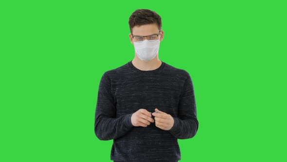 Coronavirus Man Wearing Protective Mask Cleaning His Hands with Sanitizer on a Green Screen, Chroma