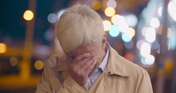 Bokeh Shot of Stressed Aged Man Crying Outdoors