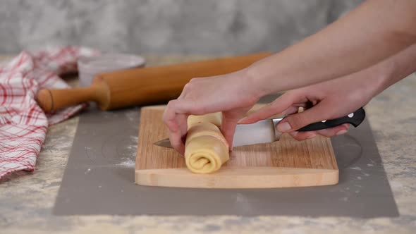 Chef Cuts with a Knife in Equal Portions for Baking Crispy Buns