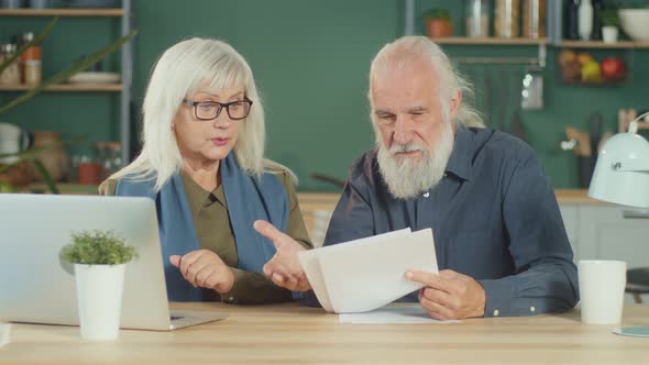 A Worried Elderly Couple Discussing Unpaid Bank Debt Checking Expenses