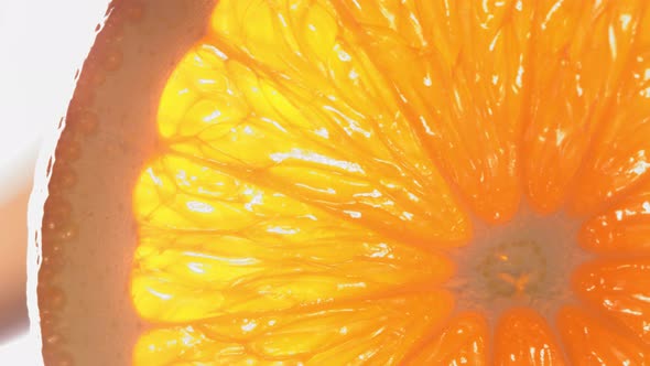 Drop of Water Flows Down the Surface of a Ripe Juicy Orange Slice