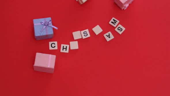 White letter tiles moving to spell out christmas with presents