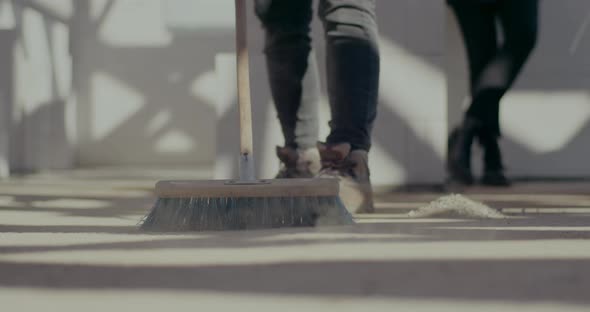 Female Worker Sweeping Floor with Broom