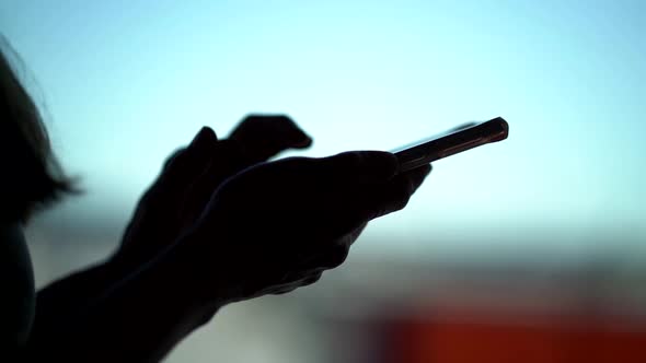 Dark Silhouette of Female Hands, Using Smartphone, Swiping and Tapping on Sensor Screen, Closeup of