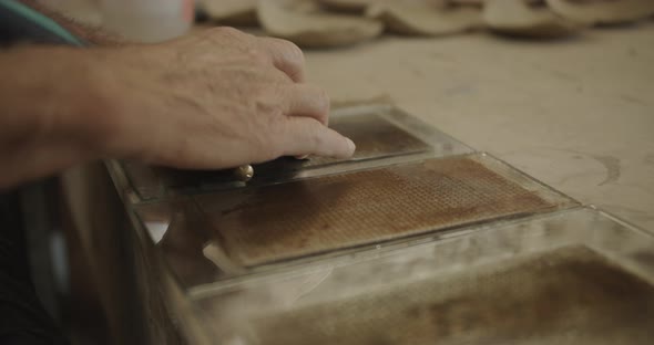 elder man hands buffing a chisel