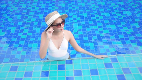 Young asian woman enjoy around outdoor swimming pool for leisure