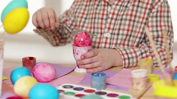 Happy Child Wearing Bunny Ears Painting Eggs on Easter Day