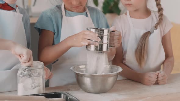 Unrecognizable Children Adding Flour to Bowl