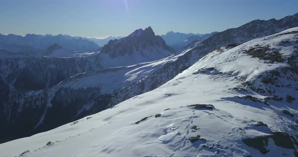 Aerial drone view of snow covered mountains in the winter.