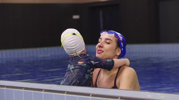 Young Woman Instructor with a Little Kid in the Swimming Pool