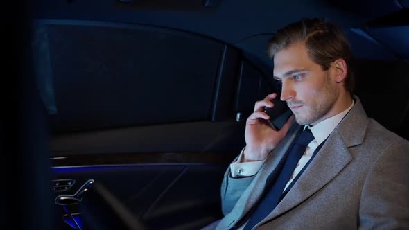 Businessman Sitting in a Moving Car and Using Laptop Top Manager in a Suit is Sitting in the Back of