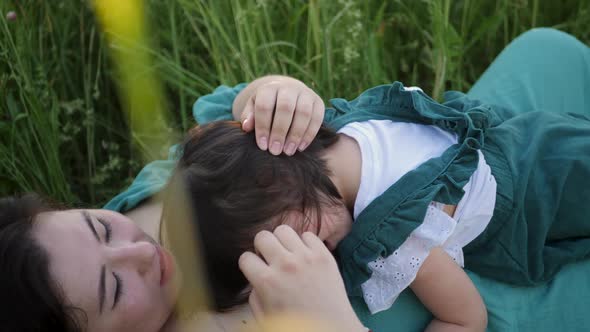 Koreans Family Mother and Daughter in Green Dresses Sitting in the Long Grass