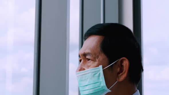 Senior man wearing protective face masks during quarantine at home.