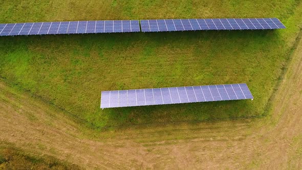 Aerial view of solar panel rows near a forest during Autumn, Estonia.