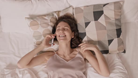 Woman Chatting on Phone in Bed