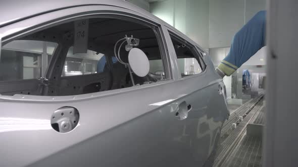 Robotic Arms Spray Painting a Vehicle Body at a Car Manufacturing Factory