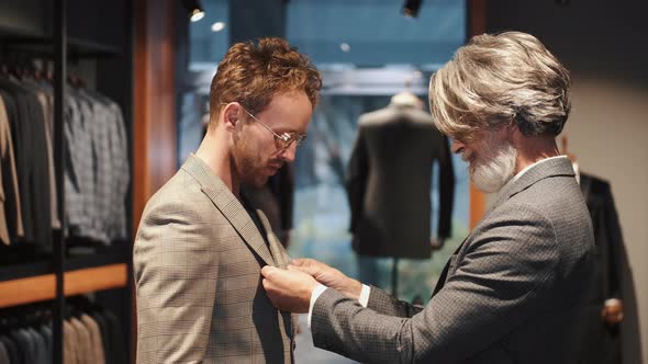 Man Trying Business Suit on with Consultant at Men Clothing Store