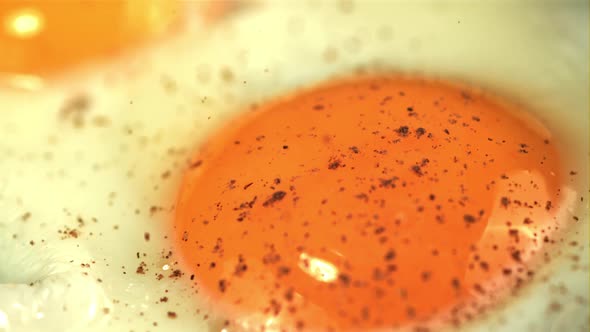 Super Slow Motion Ground Pepper Falls on the Fried Egg