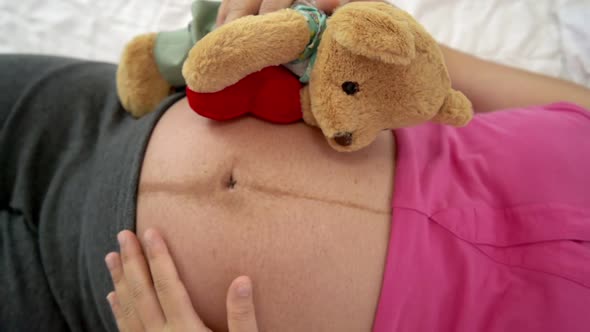 Happy Pregnant Woman Sleeping on Bed in Bedroom