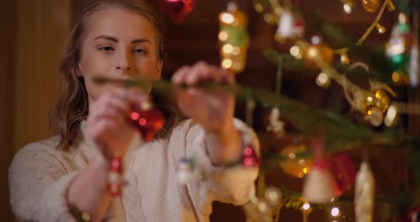 Woman Decorating Beautiful Christmas Tree in Living Room