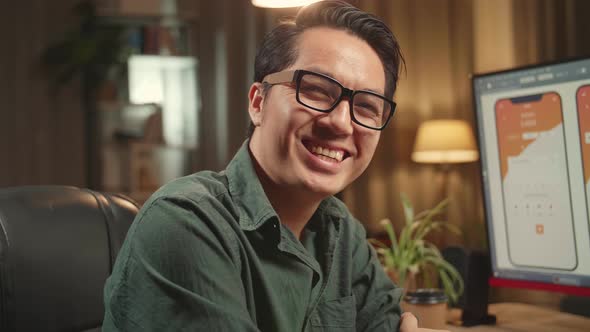 Asian Male Mobile Application Developer Works With Graphics On His Personal Computer