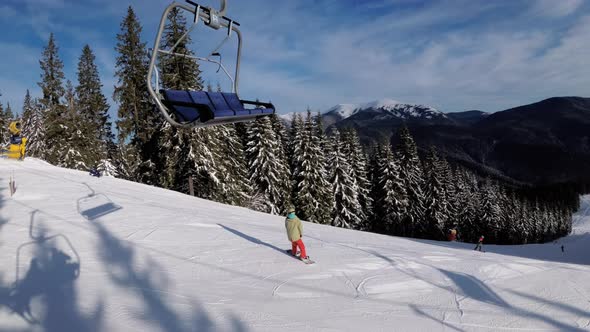 POV From Ski Chair Lift To Snowy Ski Slope, Skiers Slide on Ski Slope, Ski Resort