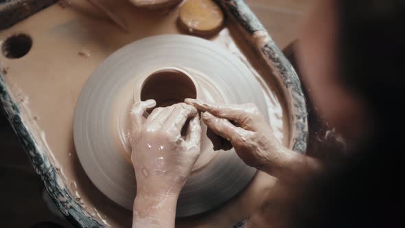 Man Potter Working on Potters Wheel Making Ceramic Pot From Clay in Pottery Workshop