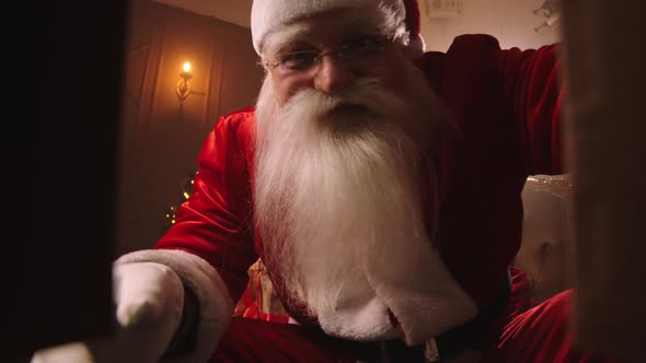 Santa-Claus Is Opening Box with Gift and Taking Camera, Talking with It, Smiling Face of Old Wizard