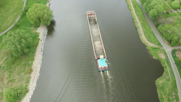 Aerial View of Large Cargo Barge Moving Along the River