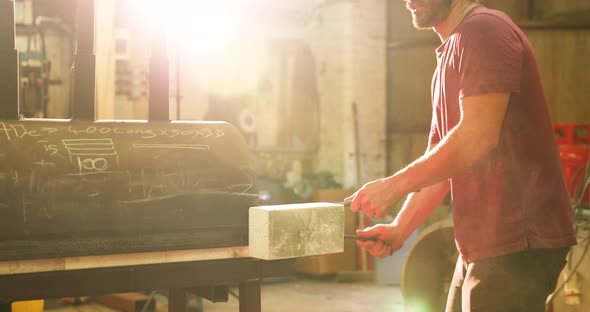 Bladesmith taking hot steel out of kiln