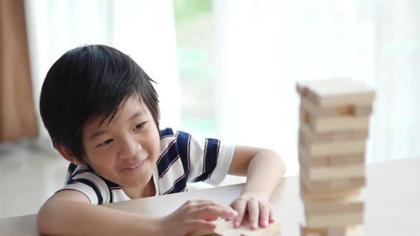 Cute Asian Child Playing Wood Blocks Stack Game