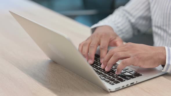 Close Up of African Businessman Typing on Laptop