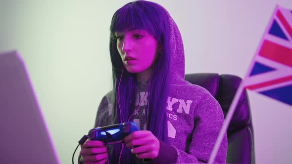 British Gal Pal Streamer Learns How to Use a Gamepad on Her Laptop Medium Shot