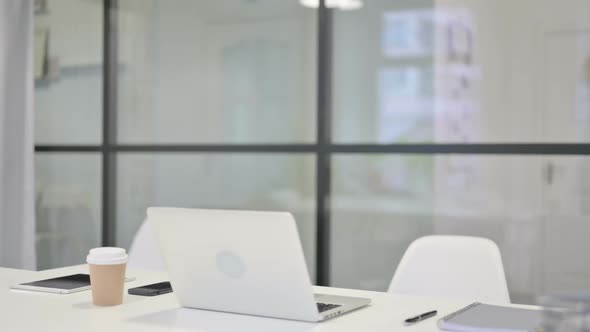 Young Businessman Coming Back Opening Laptop in Office