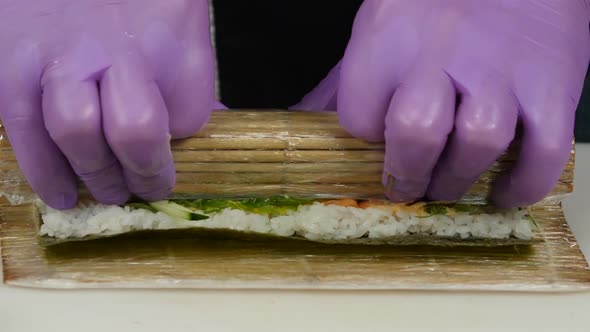 Chef Uses a Bamboo Mat for Preparing Sushi. Close Up