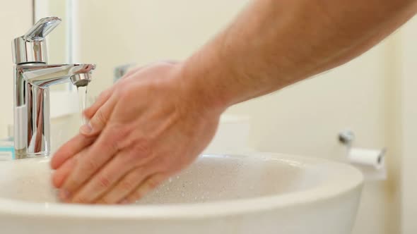 Mid section of man washing hands in basin 4k