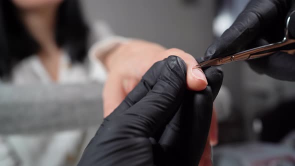 Manicure Applying Cutting the Cuticle with Scissors