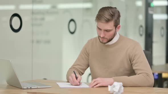Creative Young Man Failing to Write on Paper