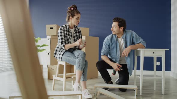 Tracking right video of couple installing bookshelf in new house. Shot with RED helium camera in 8K