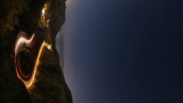Night time lapse of a road winding through the mountains