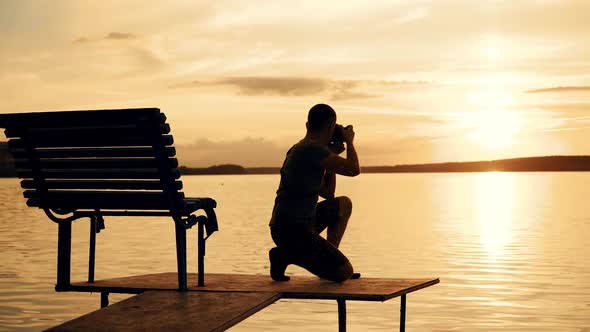 Silhouette photographer on the golden beach during sunset. Work on vacation