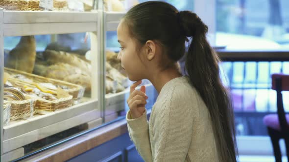 Cute Little Girl Looking at the Display at the Local Bakery