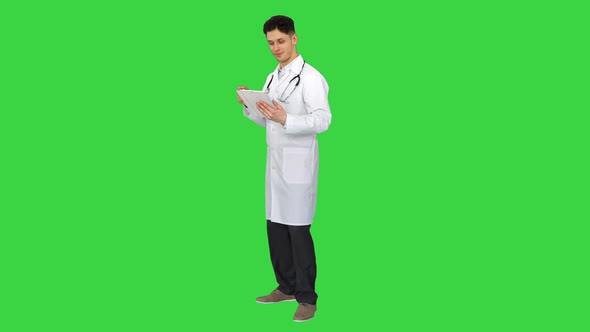 Attractive Confident Doctor Dancing with Tablet After Reading the Results on a Green Screen, Chroma