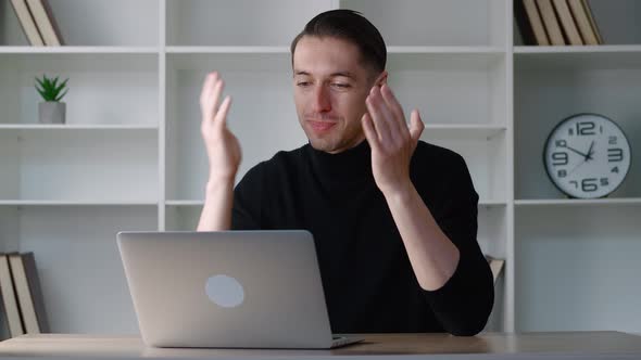 Smiling Businessman Using Laptop Computer for Video Conference While Sitting at Modern Office