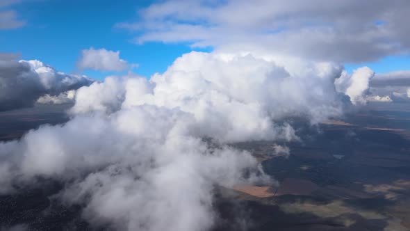 Aerial View From Airplane Window at High Altitude of Earth Covered with Puffy Cumulus Clouds Forming